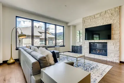 The Lion Vail residence living room with fireplace and views via Expedia